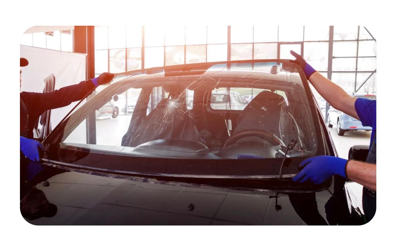Technicians removing a cracked car windscreen