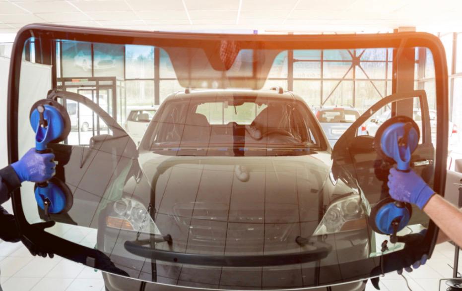 New windscreen held with suction cup handles ready for installation