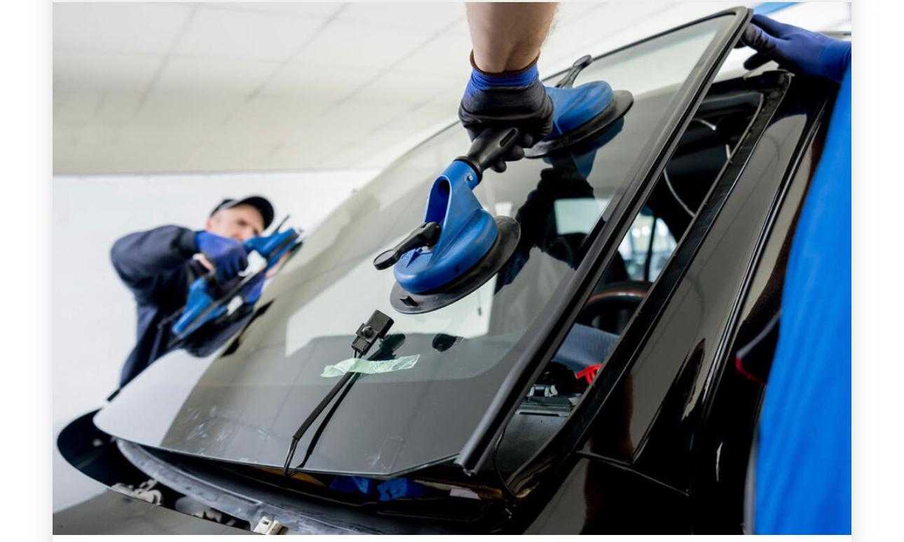 Close-up of a technician using professional suction handles during windscreen fitting